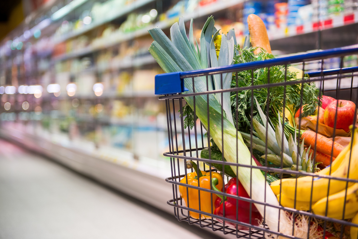 Carrinho de compras em supermercado cheio de alimentos saudáveis