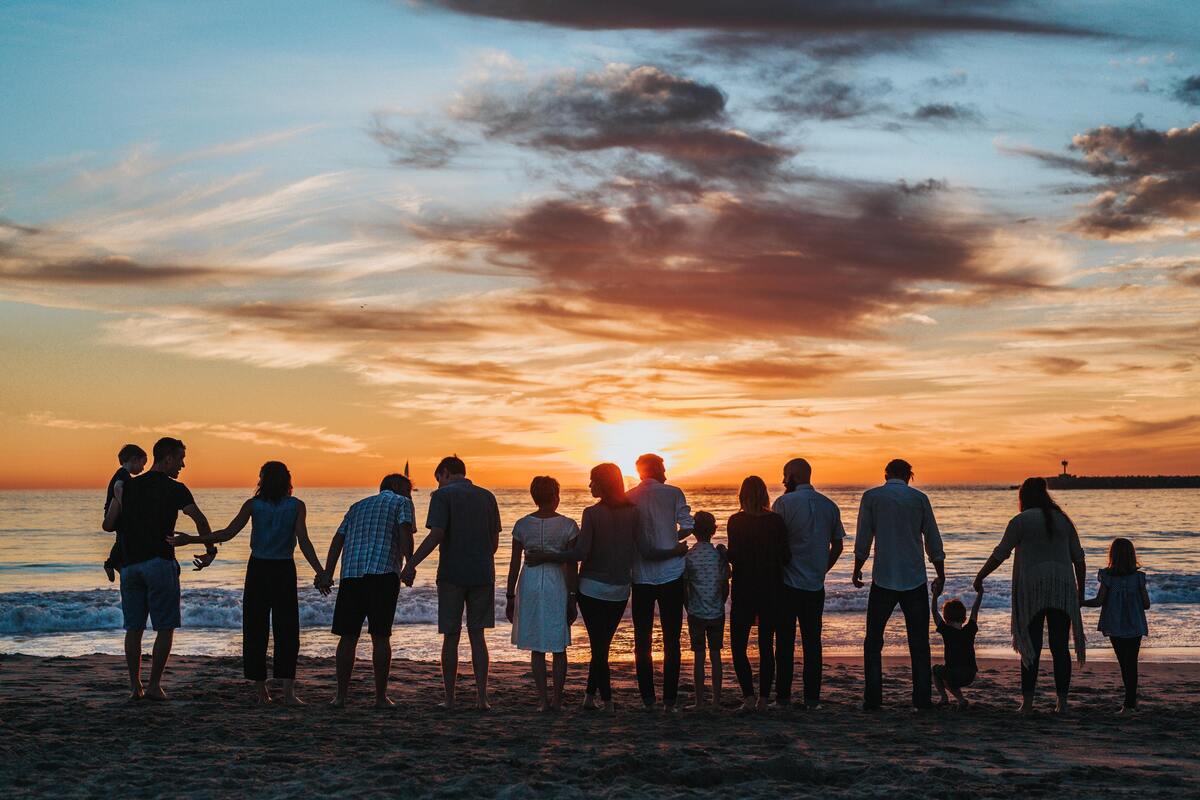 Pessoas de mãos dadas na praia.