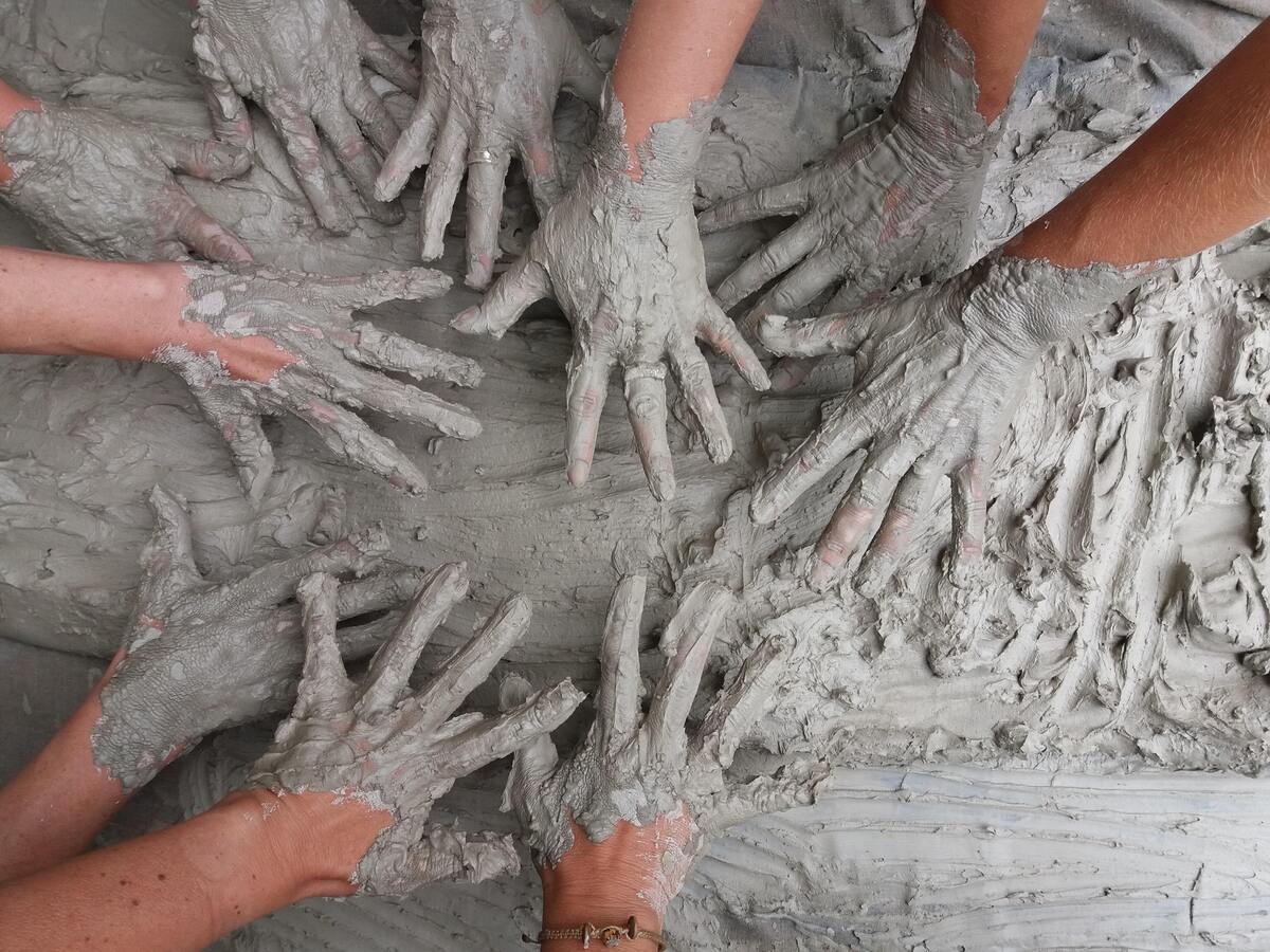 Pessoas com as mãos sujas de tinta.