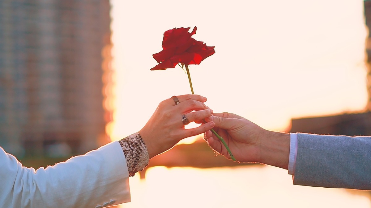 Homem presenteando mulher com uma flor.