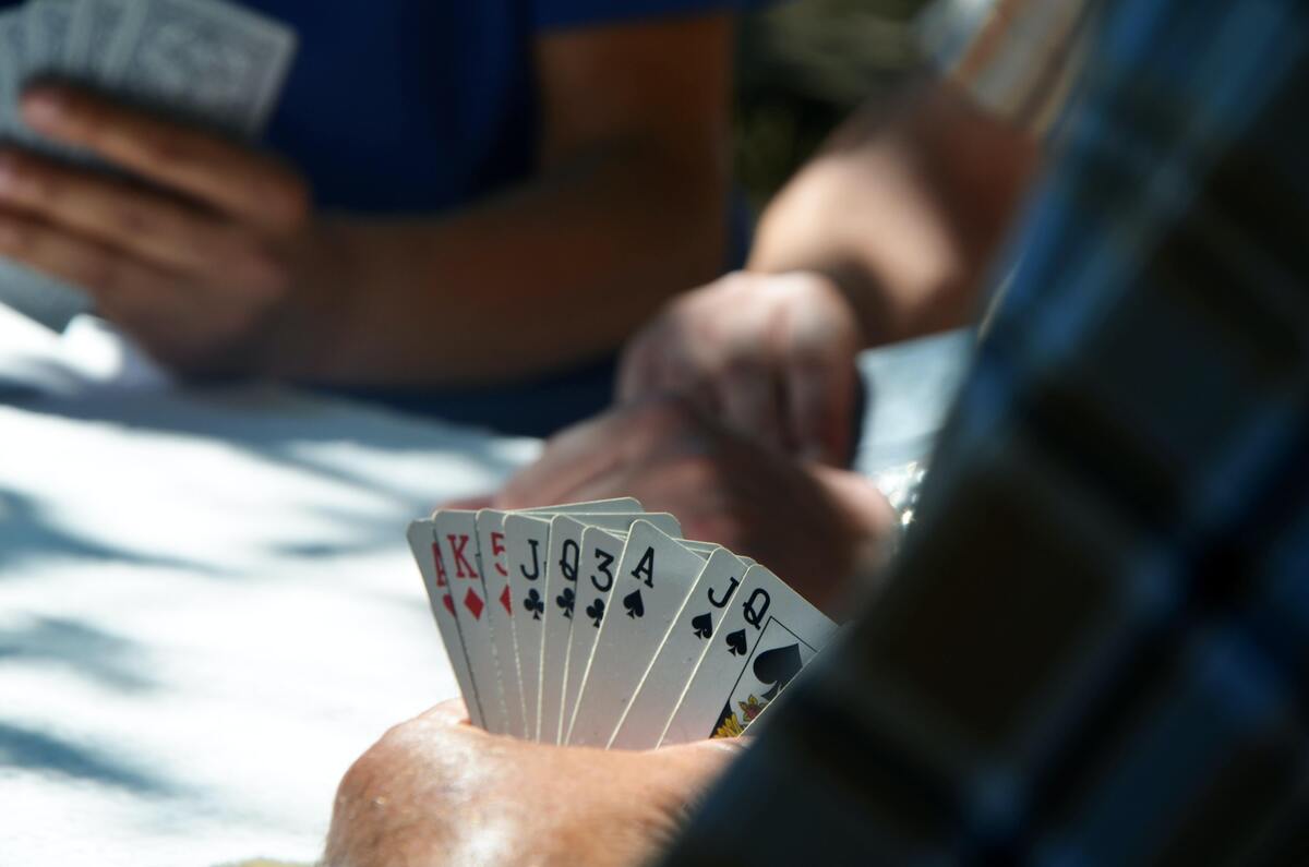 Homem segurando cartas de baralho.