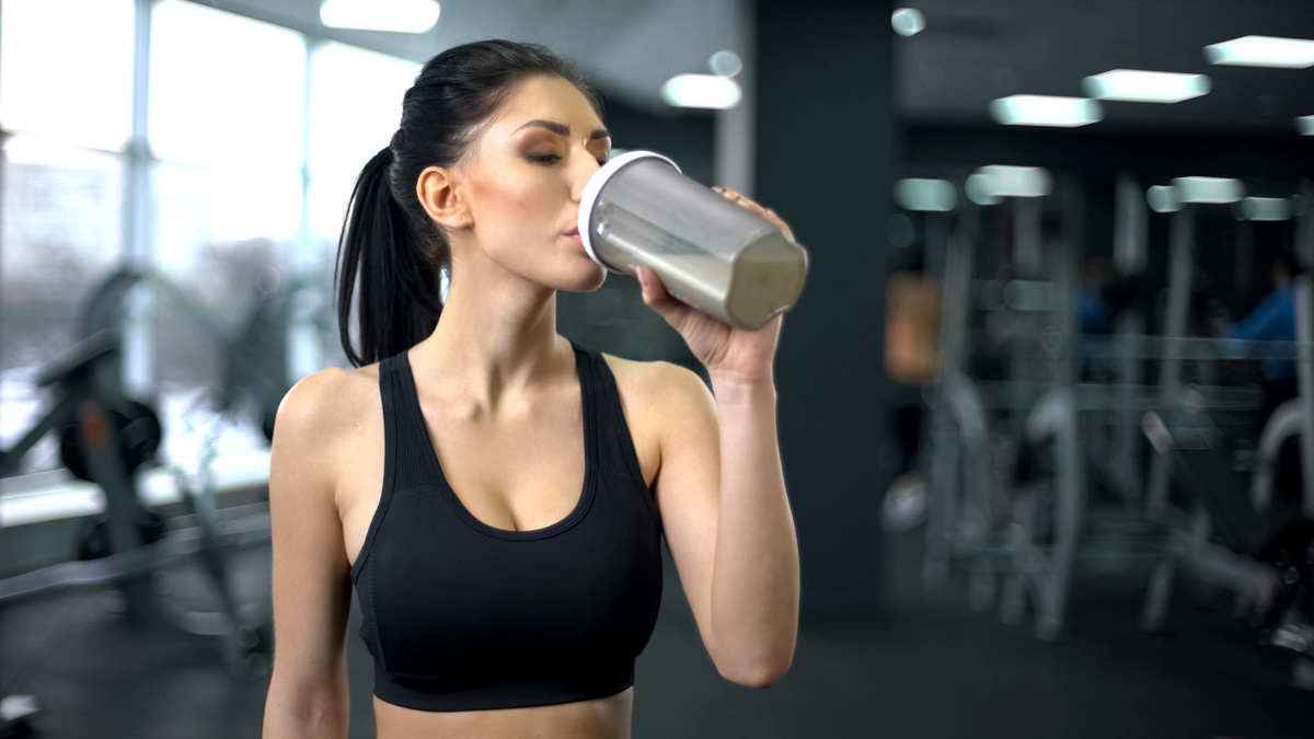 Mulher tomando shake na academia