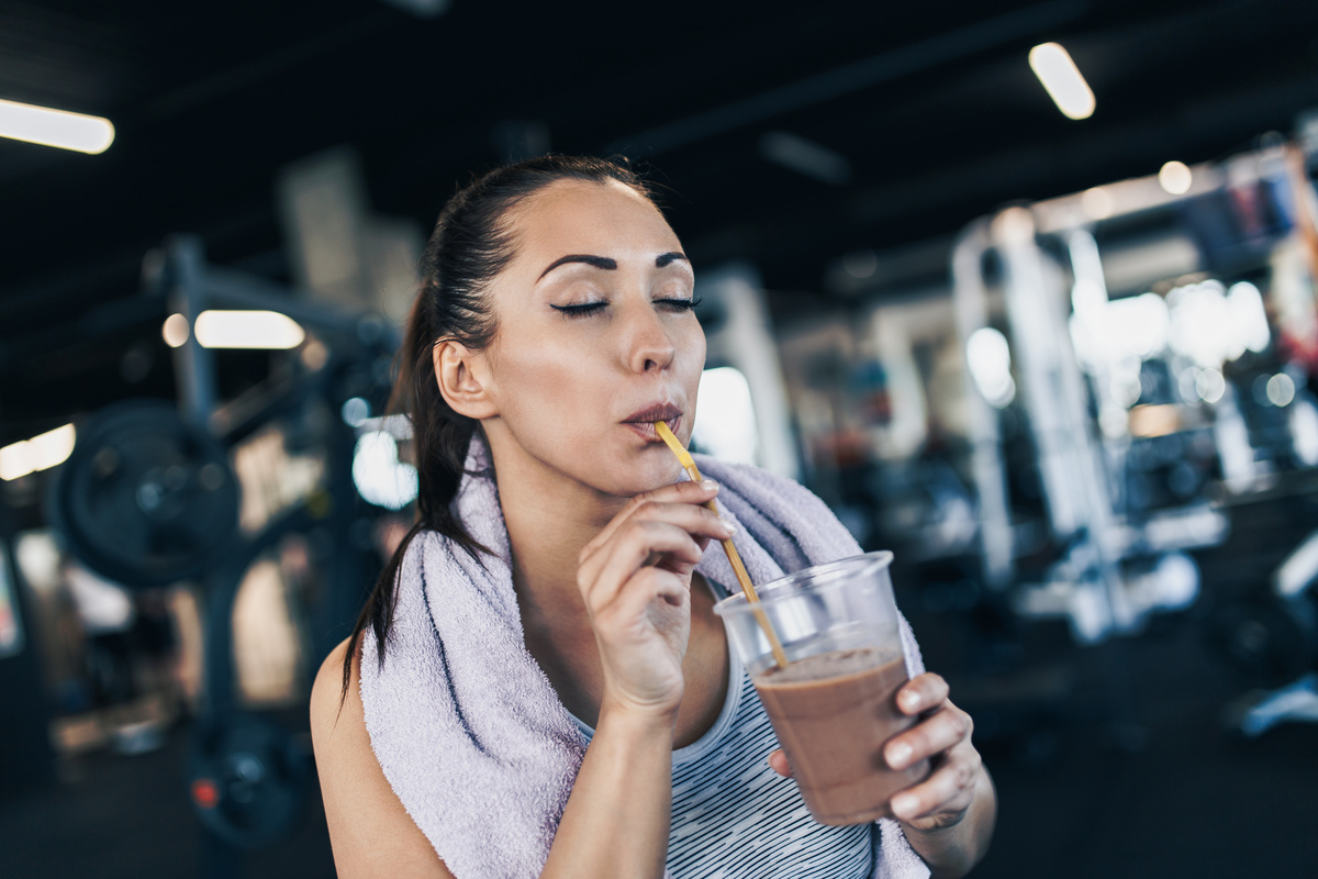 Mulher tomando shake na academia