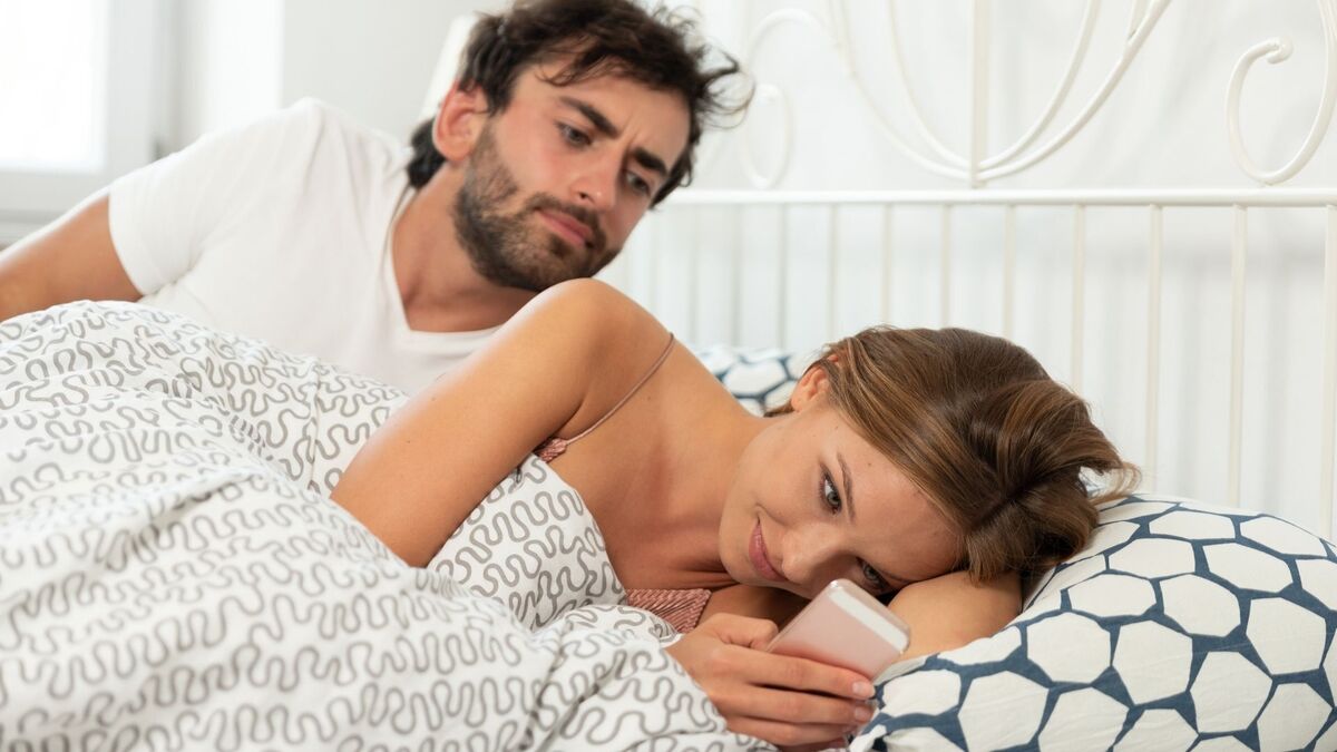 Homem pegando traição da mulher na cama.