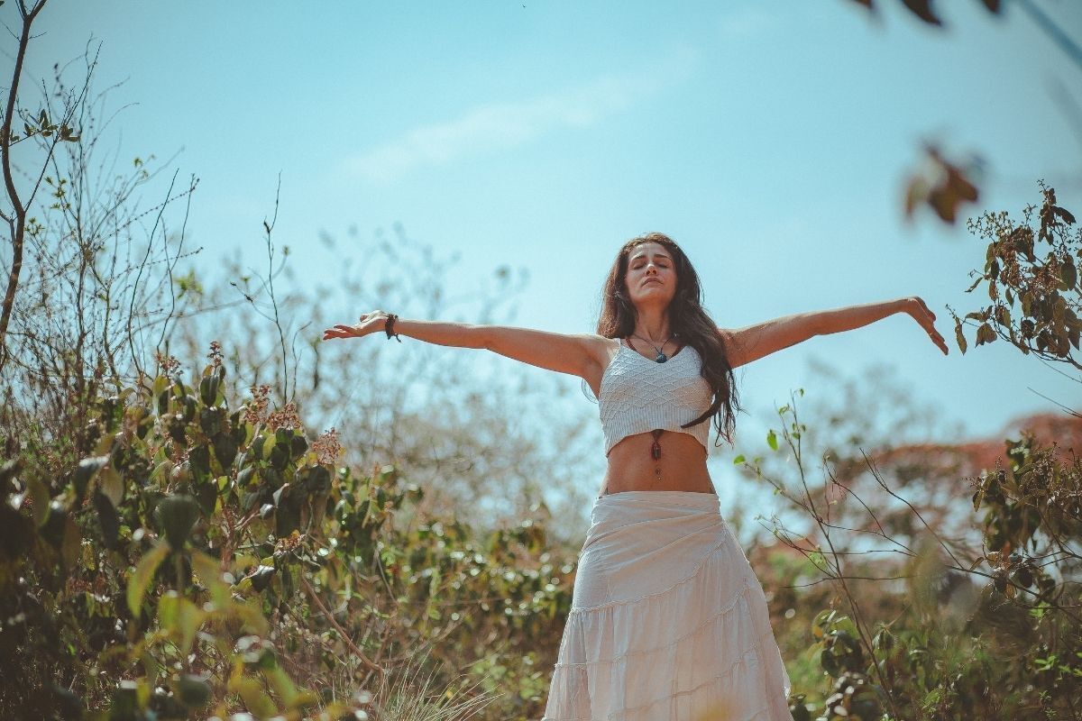 Mulher meditando com os braços abertos