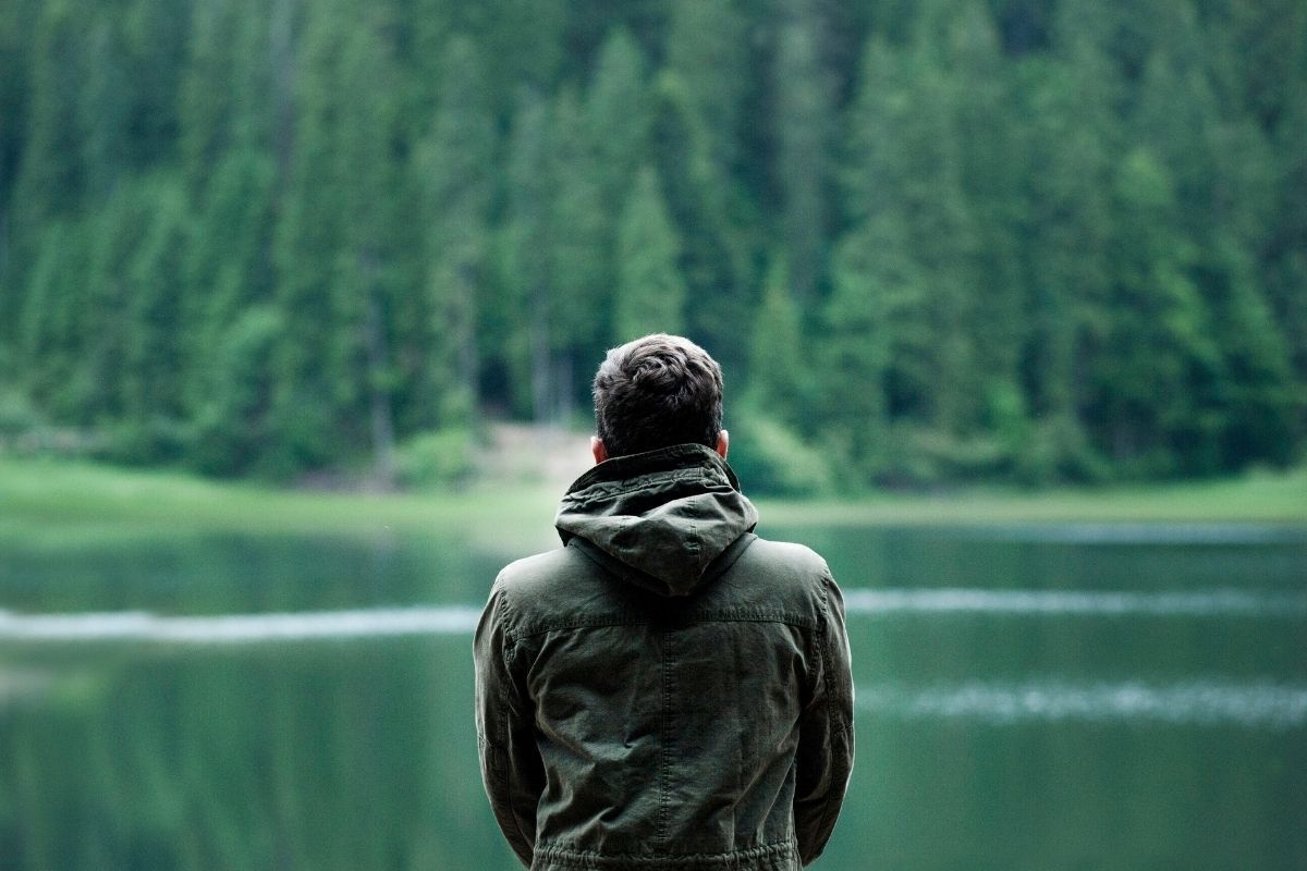 Homem de costas apreciando a vista da natureza