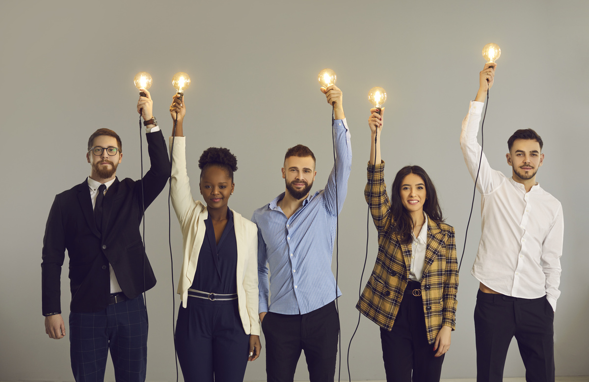 Colegas de trabalho segurando lâmpadas