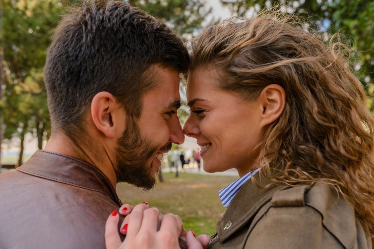 Casal sorrindo com os rostos próximos