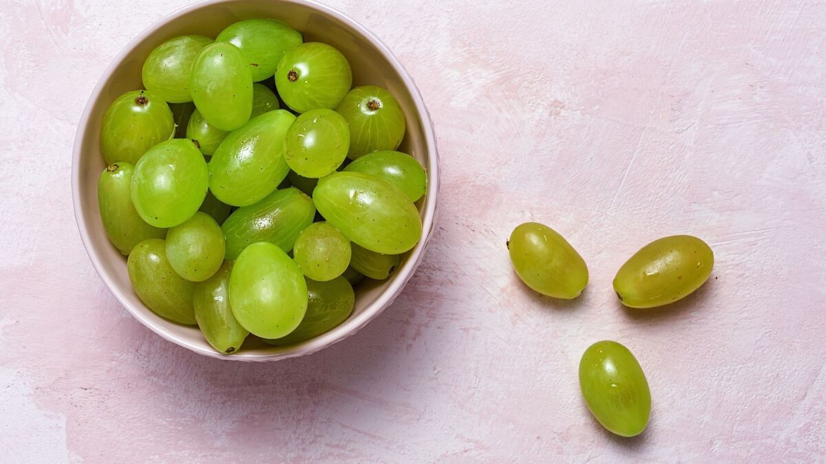 Uvas dentro e fora de uma tigela.