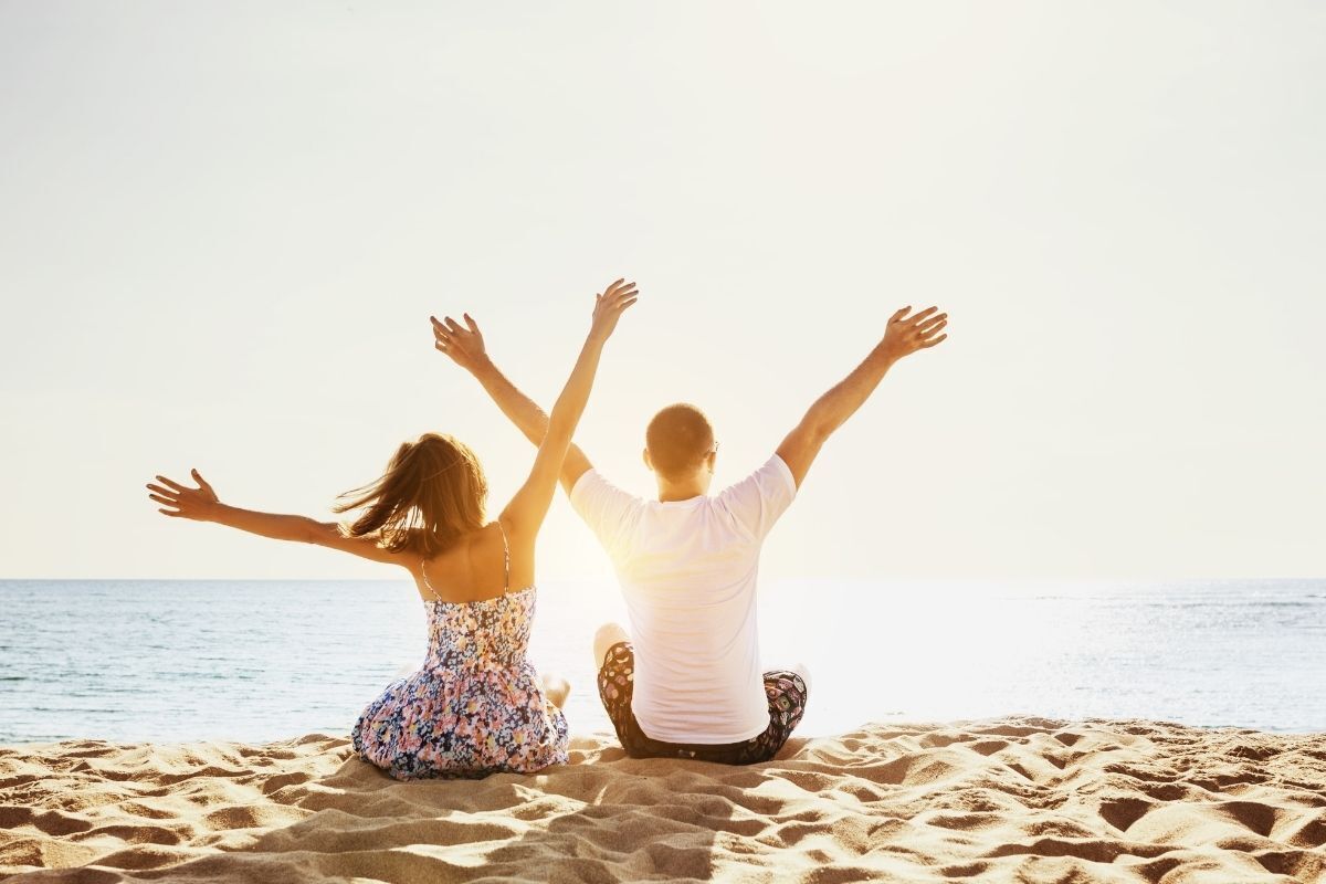 Casal feliz e livre olhando o mar