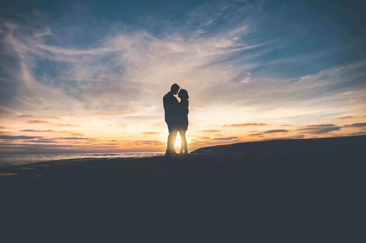 Casal se abraçando no pôr do sol