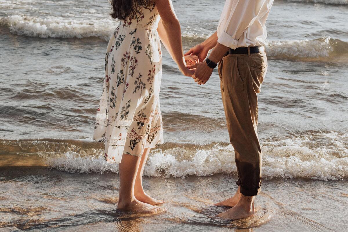 Casal de mãos dadas na praia