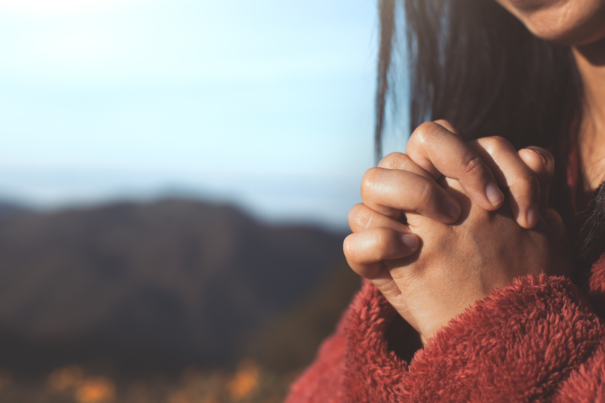 Mãos femininas em sinal de oração