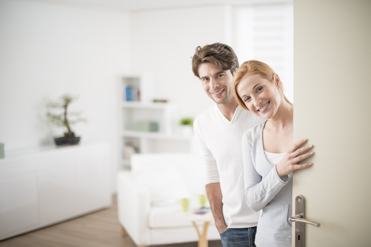 Casal na porta de casa recebendo visita