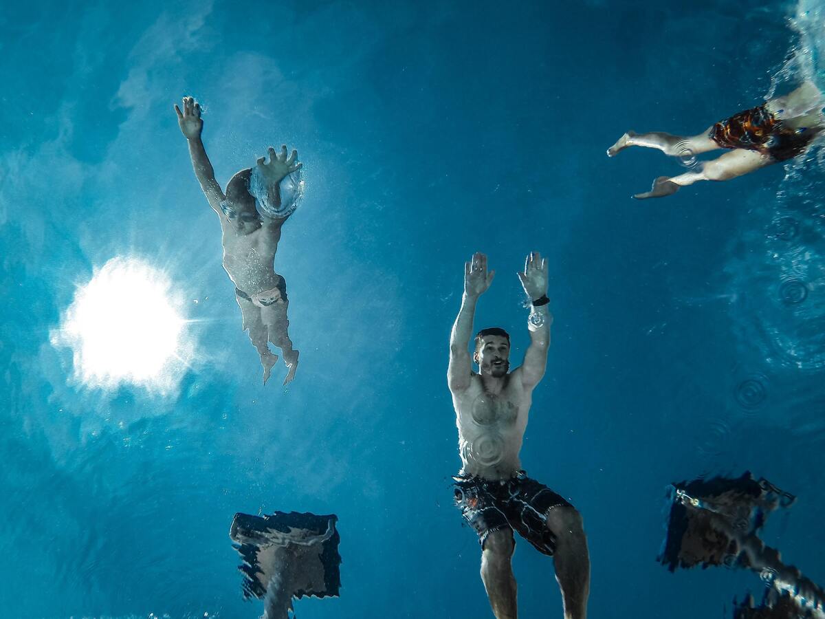 Pessoas vistas de baixo prestes a cair na piscina. 