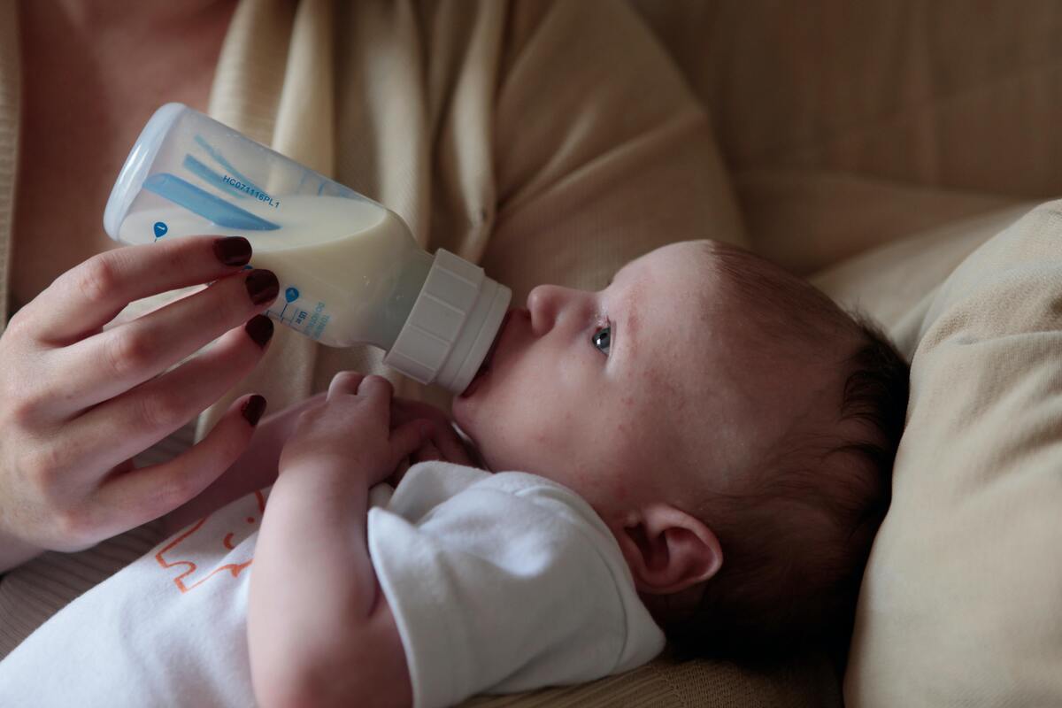 Mãe alimentando filho com mamadeira