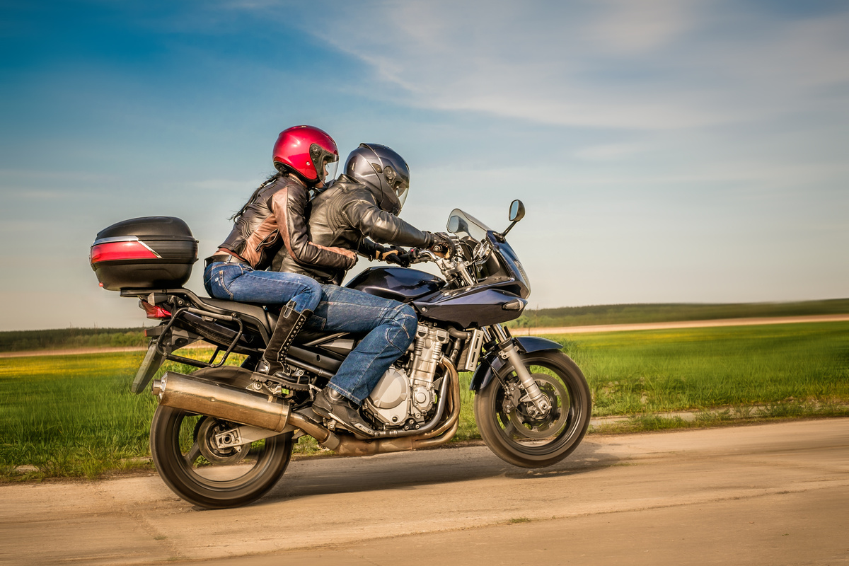 Casal fugindo de moto em uma estrada