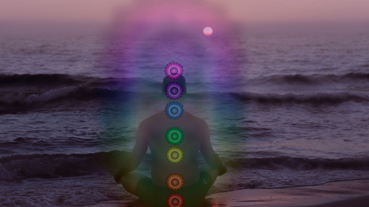 Pessoa com os chakras destacados no mar.