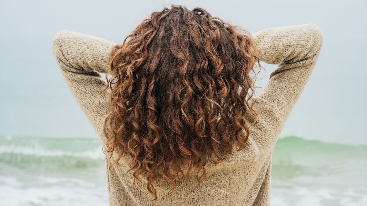 Mulher com cabelo cacheado.