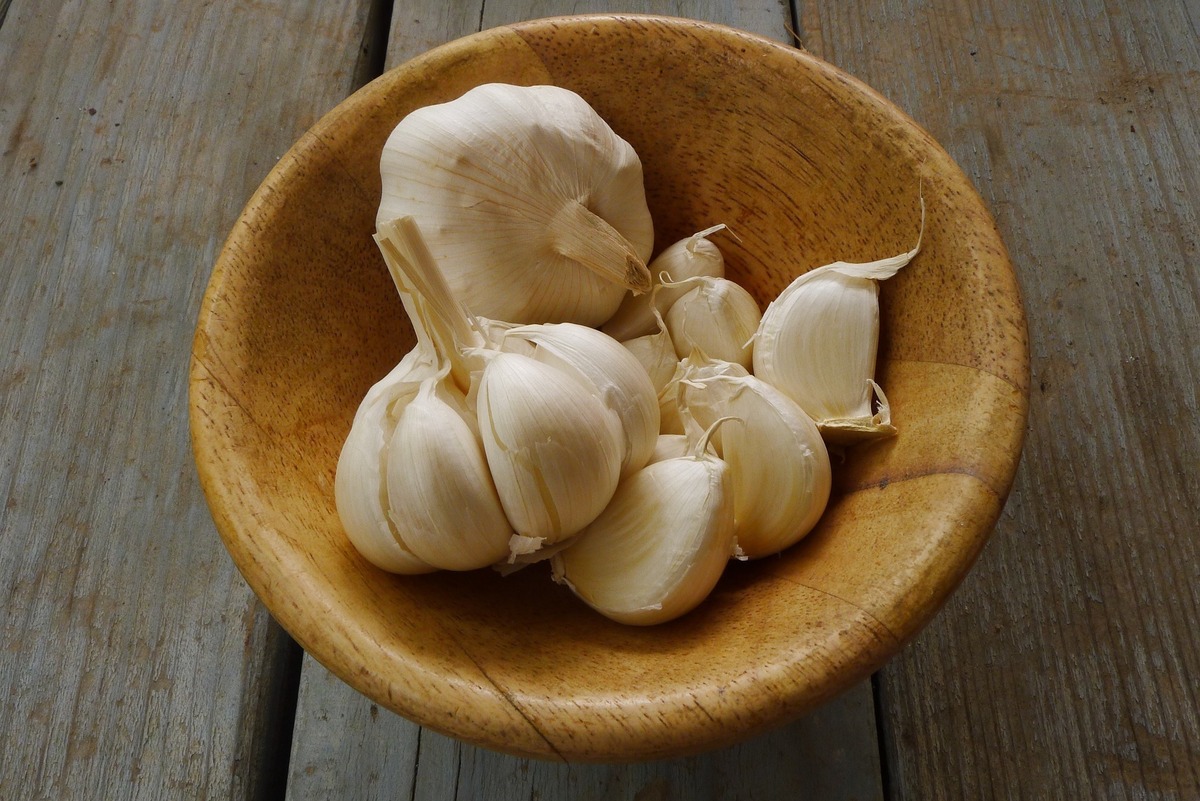 Pote de cerâmica com várias cabeças de alho dentro.