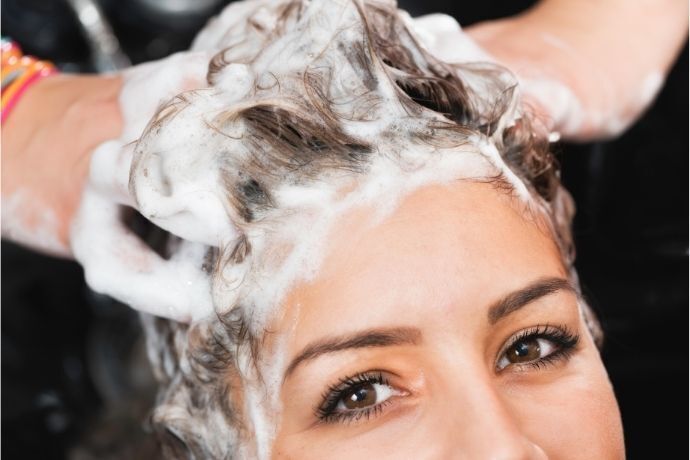 Mulher com cabelo com espuma de shampoo