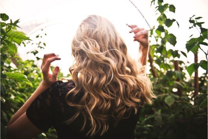 Mulher loira entre plantas ao ar livre