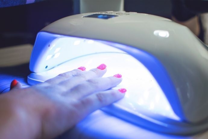 Mãos femininas dentro de cabine de secagem