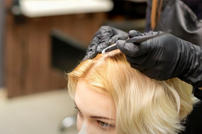 Mulher pintando o cabelo de loiro claro