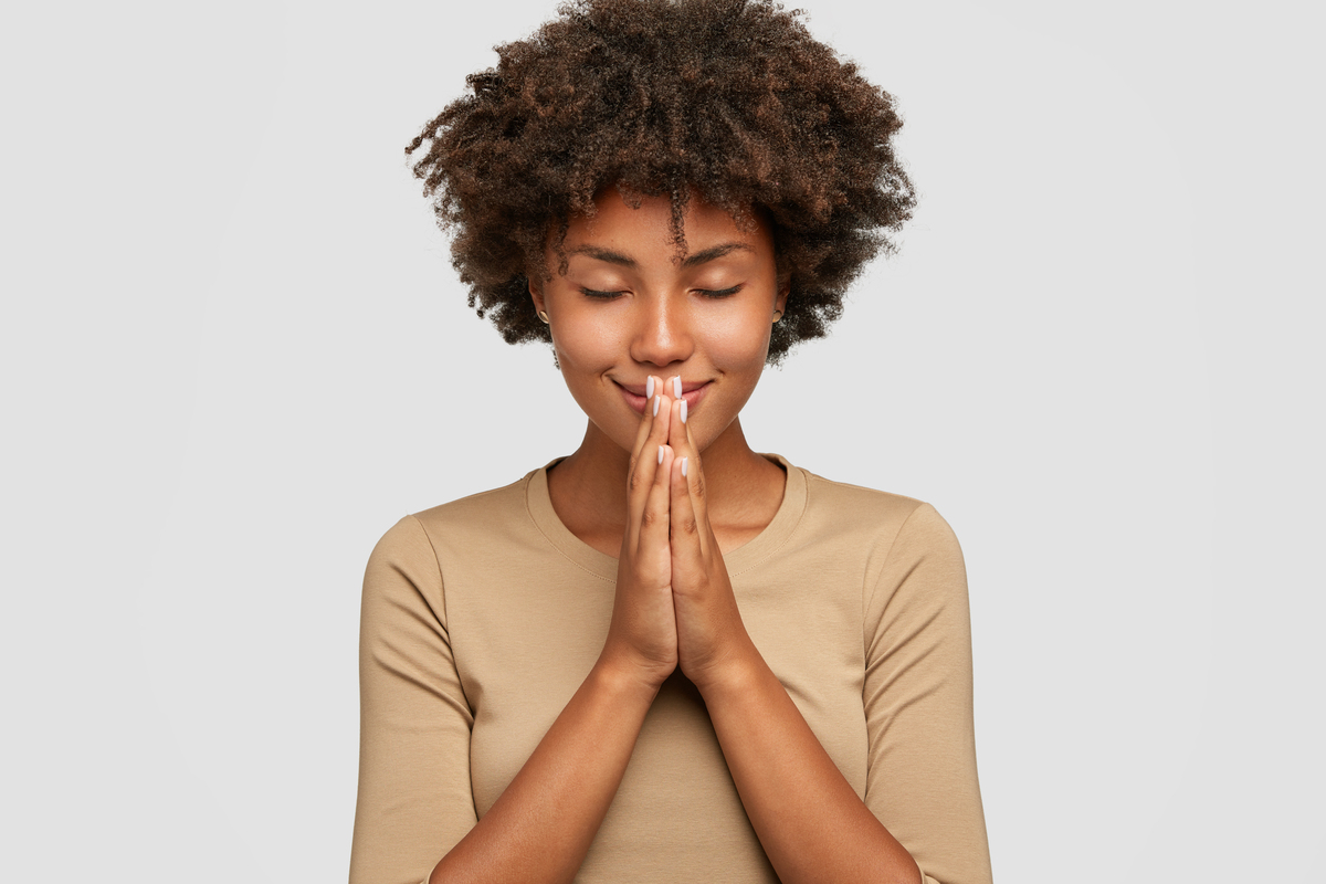 Mulher agradecendo com as mãos juntas