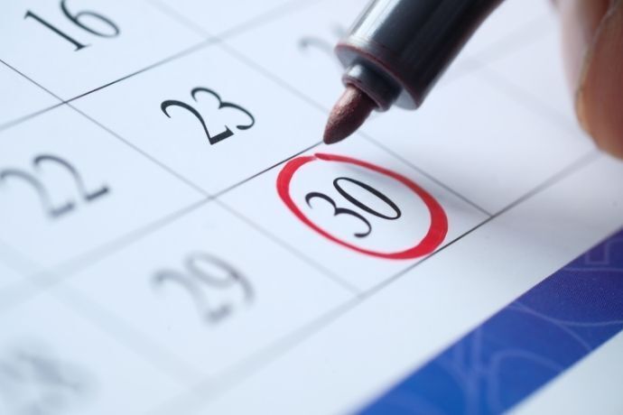 Caneta vermelha circulando o dia 30 em calendário