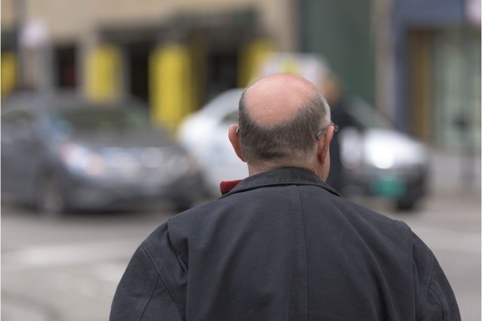 Homem careca andando na rua