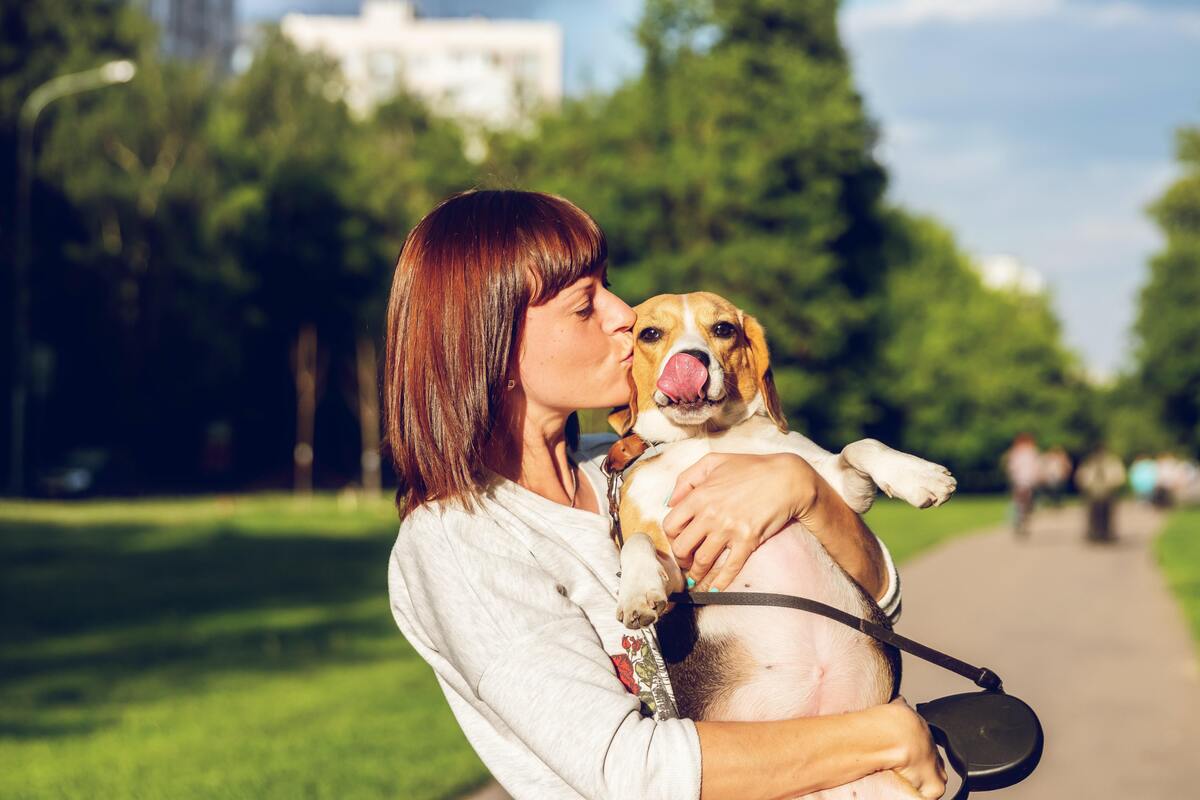 Mulher com cachorro no colo. 