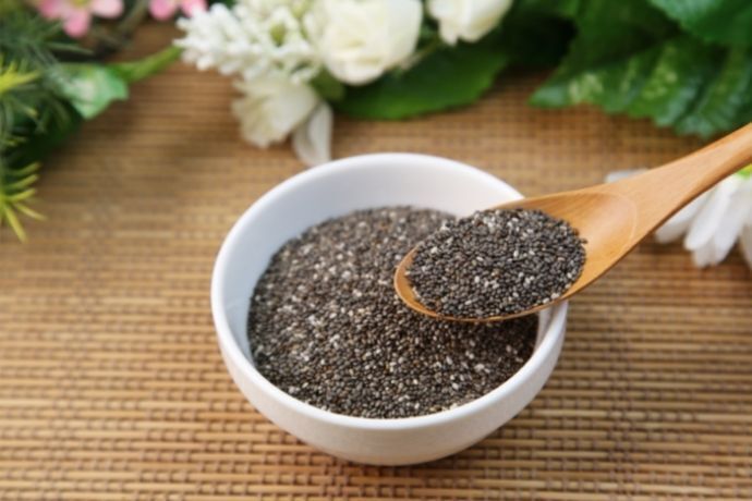 Sementes de chia em pote de porcelana e colher de madeira