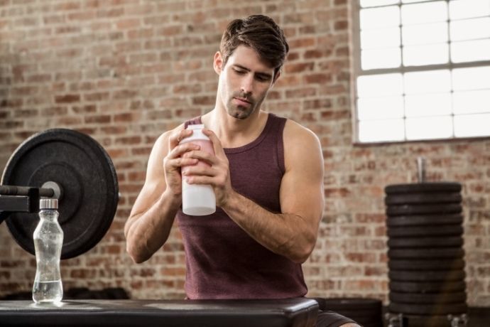 Homem em academia sacudindo um shake