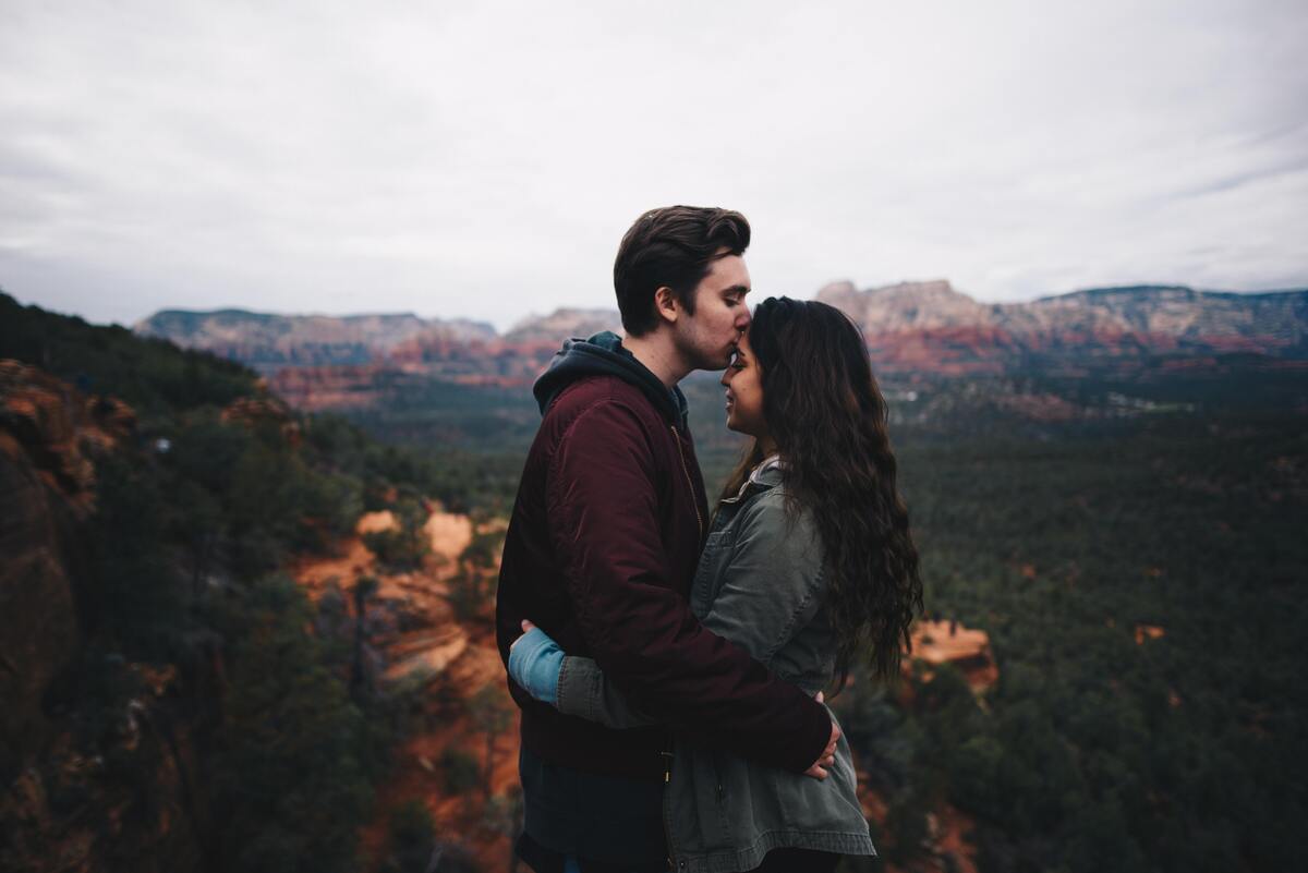 Casal: homem beijando a testa da mulher. 