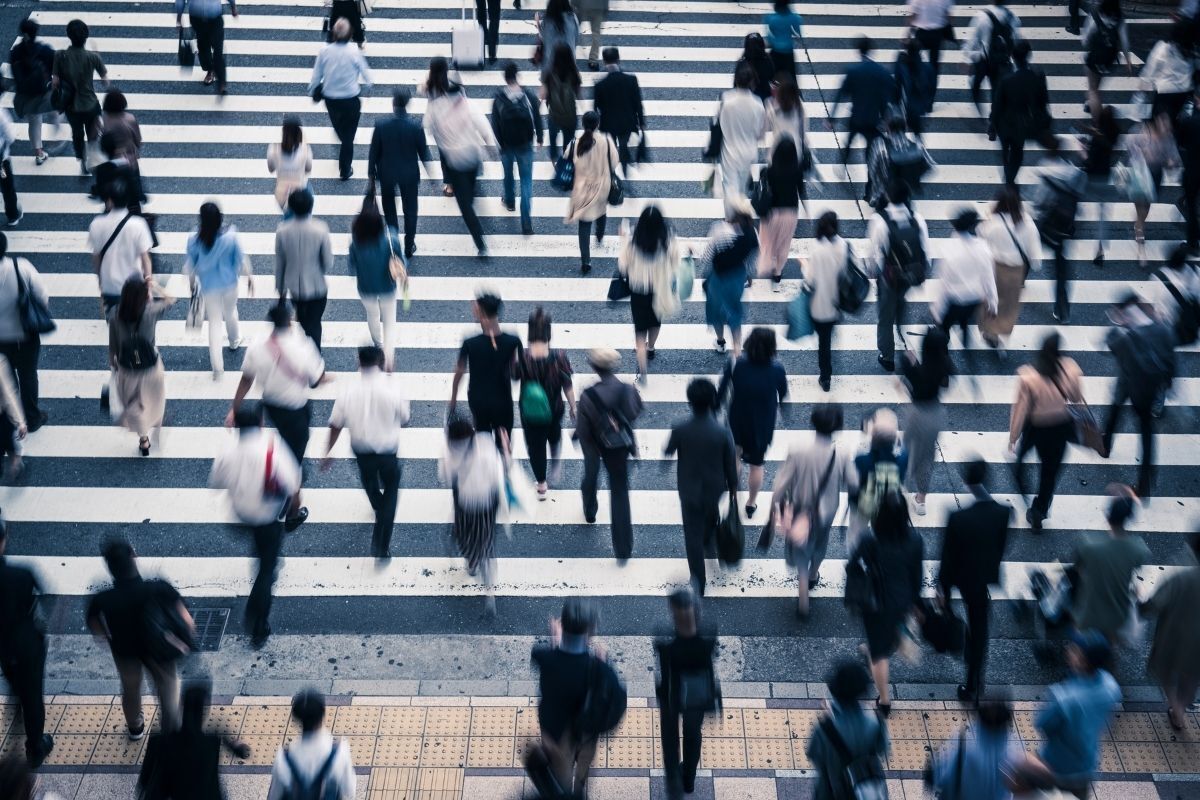 Pessoas caminhando em rua cheia.