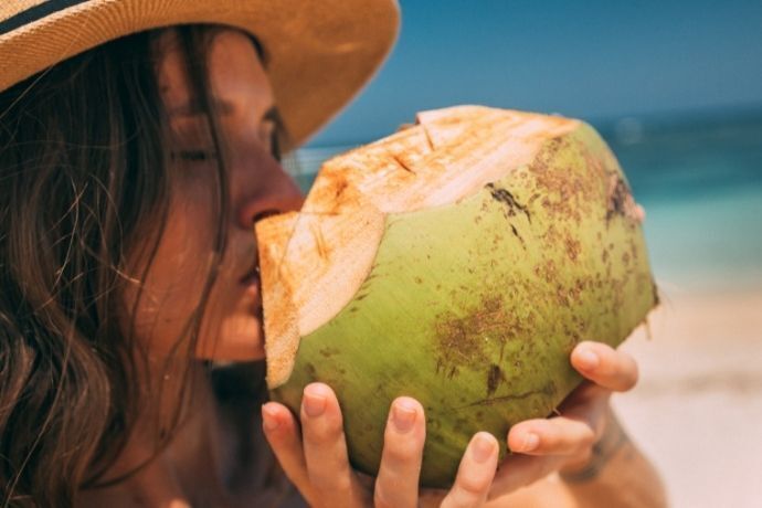 Mulher tomando água de coco