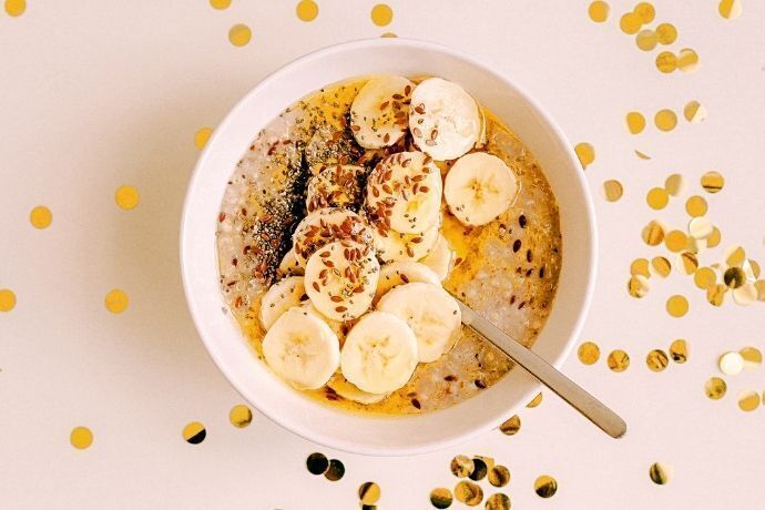 Pote com banana cortada, sementes e leite