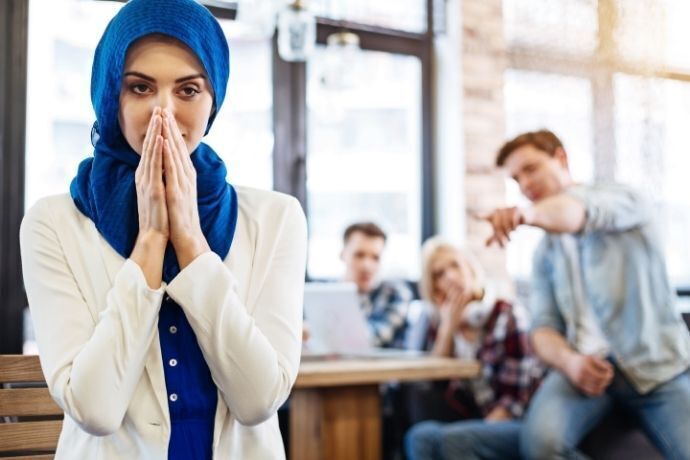 Mulher com véu na cabeça sendo humilhada por homens