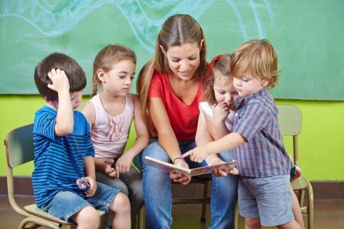 Professora lendo livro com crianças na creche