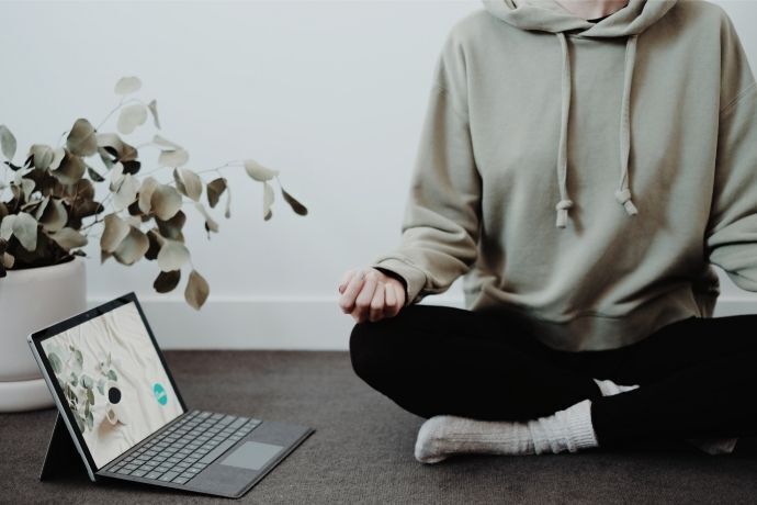 Mulher meditando ao lado de notebook