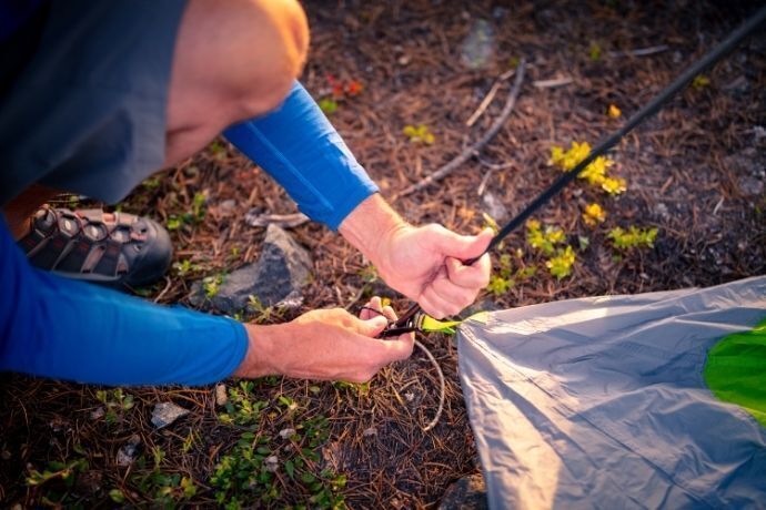 Pessoa montando barraca de camping 