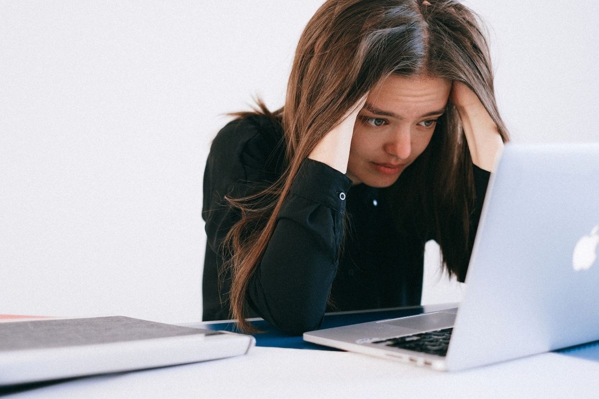 Mulher estressada em frente a notebook.