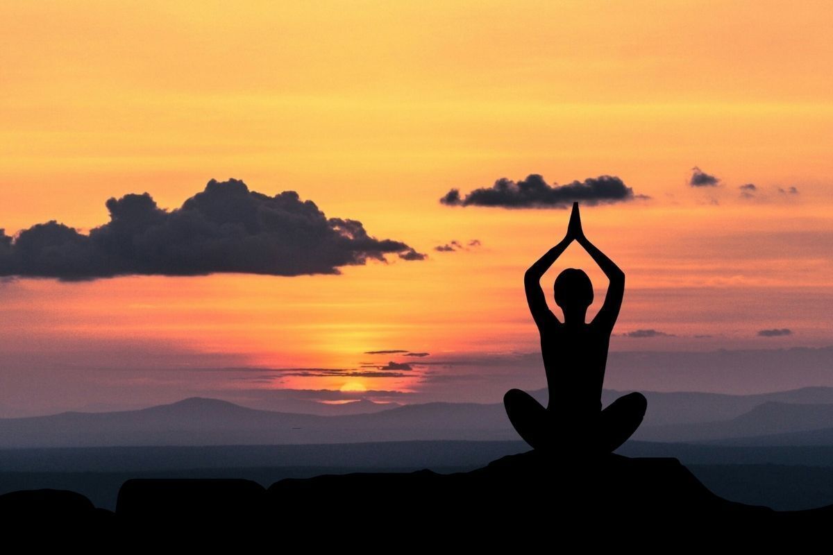 Mulher praticando yoga ao ar livre.