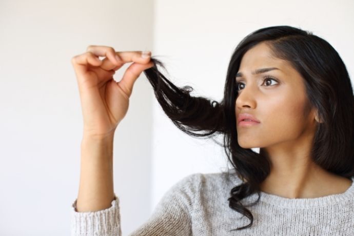 Mulher olhando cabelo sujo