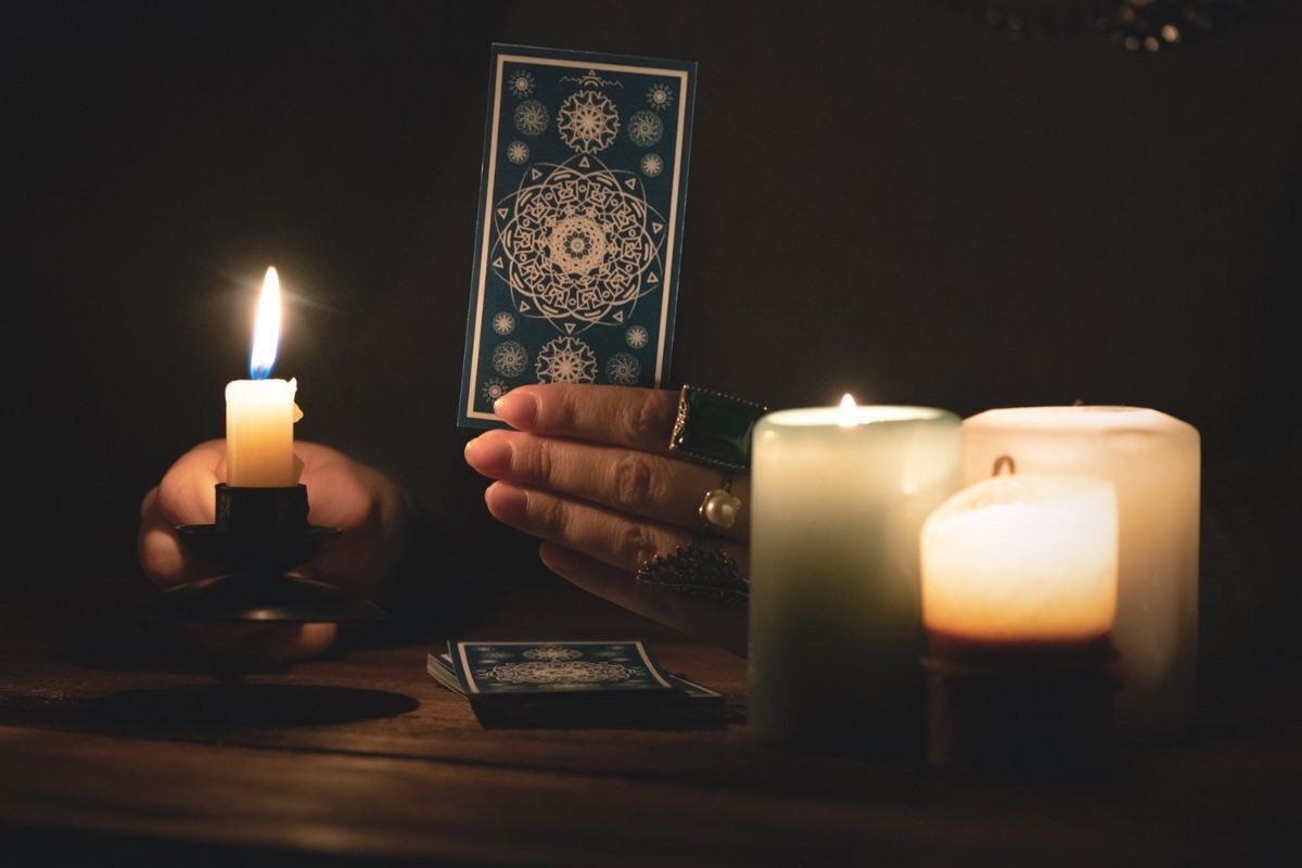 Mão segurando carta de Tarot.