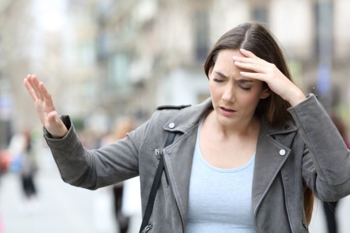 Mulher na rua sentindo tontura