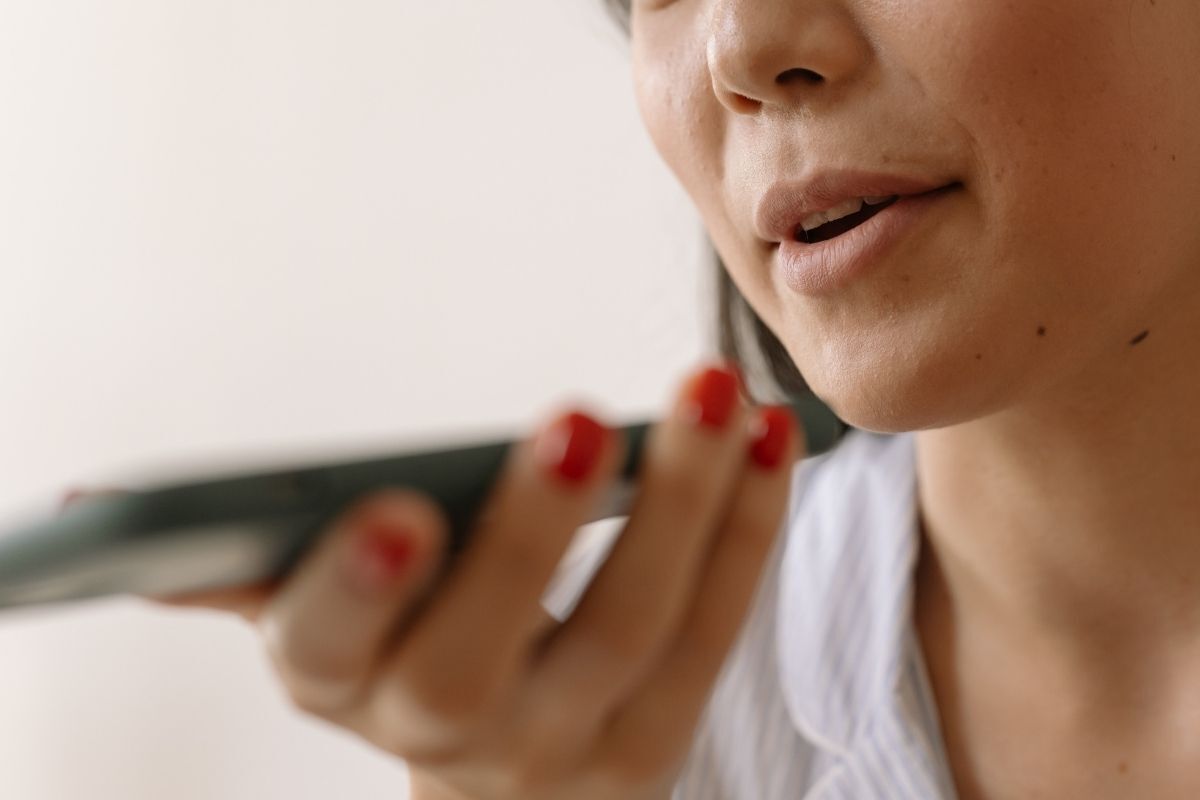 Mulher mandando mensagem de voz no telefone.