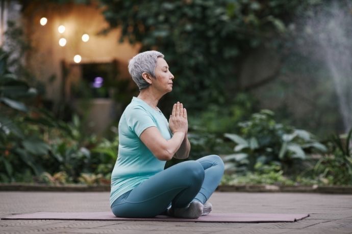 Senhora fazendo yoga em área externa