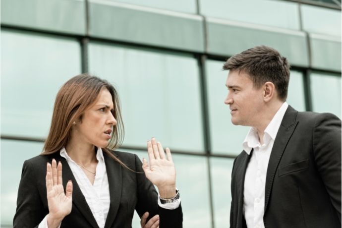 Casal discutindo em frente a um prédio